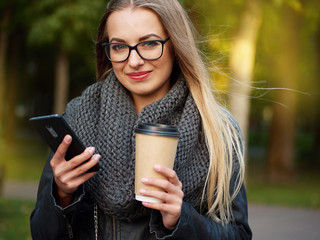 Portrait of a beautiful stylish young blonde with make-up in black leather jacket glasses and a...