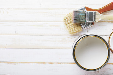 Paint brushes on wooden board prepared for painting in white. Top view on tools with copy space