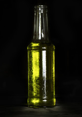 Cocktail yellow drink in bottle cold on the table / selective focus / Dark style and category drink food / on black background isolated