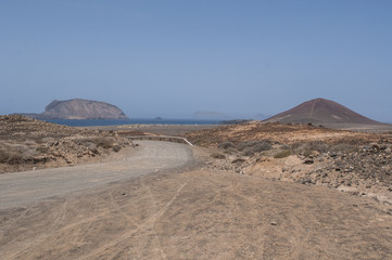 Isole Canarie: la strada sterrata per la spiaggia Playa de Las Conchas e il vulcano Montana Bermeja a La Graciosa, l'isola principale dell'arcipelago Chinijo a nord ovest di Lanzarote