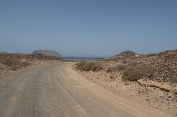 Isole Canarie: la strada sterrata per la spiaggia Playa de Las Conchas e il vulcano Montana Bermeja a La Graciosa, l'isola principale dell'arcipelago Chinijo a nord ovest di Lanzarote
