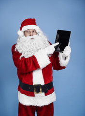 Surprised santa claus holding digital display .