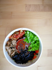 Bibimbap, traditional Korean dish in a take away box, rice with vegetables and beef. Top view, overhead, flat lay
