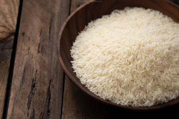 raw rice on wood plate