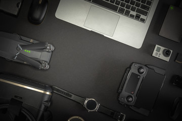 Work space professional photographer flight kit on quadcopter with VR glasses. Top view on black table background. Concept of mockup template.
