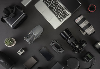 Work space professional photographer flight kit on quadcopter with VR glasses. Top view on black table background. Concept of mockup template.