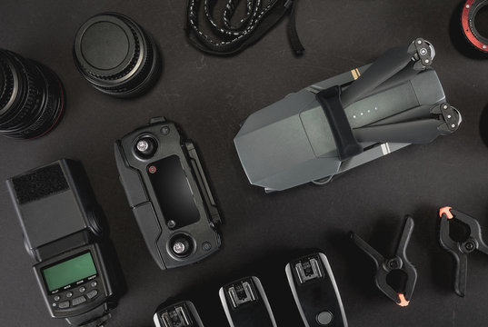 Work space professional photographer flight kit on quadcopter with VR glasses. Top view on black table background. Concept of mockup template.
