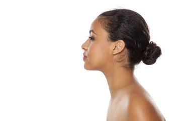 profile of young beautiful dark-skinned woman with bun on a white background