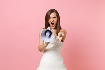 Aggressive angry bride woman in wedding dress screaming in megaphone, pointing index finger on...