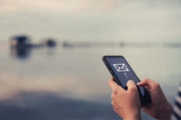 Woman hand using smartphone to send and recieve email.