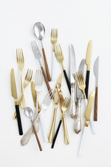 silver silverware. Black and white cutlery. Gold knives forks and spoons. Devices for eating with a wooden handle. View from above