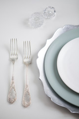 silver silverware. Devices for eating. View from above. Salt for salt from crystal. Knife and fork. White and blue plate.