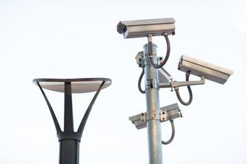 Security CCTV camera surveillance system outdoor of house. A blurred night city scape background. Modern CCTV camera on a wall. Equipment system service for safety life or asset.