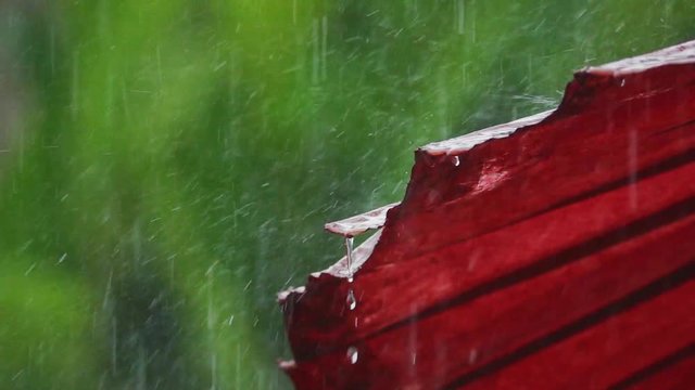 Mulberry umbrella,art and crafts product of Thailand.
Close up of raindrops bouncing and falling down from old  red paper umbrella on a heavy rainy day,slow motion.