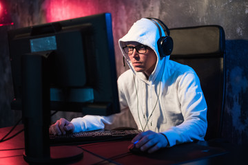Professional Boy Gamer Plays in Video Game on a eSports Tournament or in Internet Cafe. He Wears...