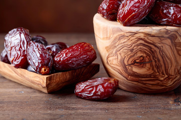 Juicy dates on wooden table .