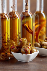 Spiced green olives and bottles with olive oil .