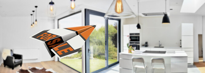 Flying paper plane with the words for sale in a modern kitchen from loft