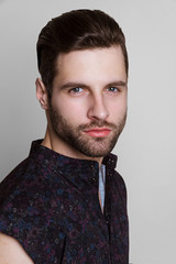 Obraz premium Handsome muscled strong face male model in fashion cloathes on white isolated font background