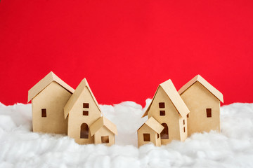 paper houses, white snow, red background with copy space, for advertising, close up