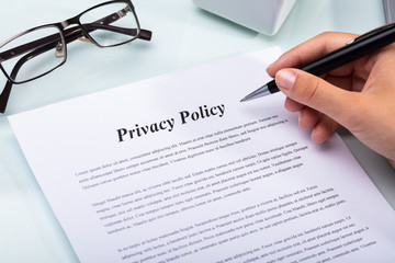 Woman Holding Pen Over Privacy Policy Form - obrazy, fototapety, plakaty