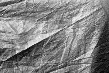 Crumpled plastic textile texture in black and white.
