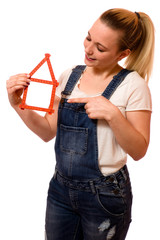 Junge Frau mit Zollstock in Hausform 