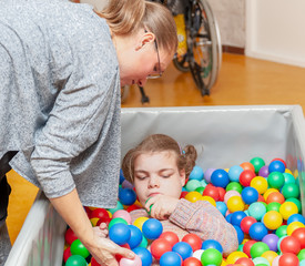 Fototapeta na wymiar Disability a disabled child having play therapy together with an experienced special needs carer.