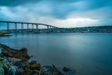 Naklejka premium View of Tromso Bridge across Tromsoysundet strait in Norway at dusk. It connects Tromso on island of Tromsoya with Tromsdalen on mainland