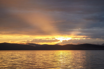 Fototapeta na wymiar Sunset on the lake in the mountains.