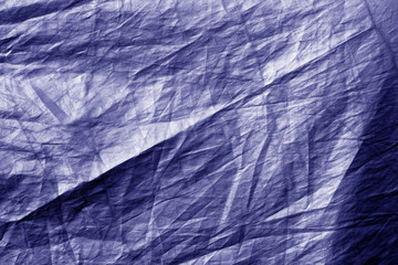 Crumpled plastic textile texture in blue tone.