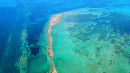 Fototapeta na wymiar Aerial drone bird's eye view photo of tropical and exotic coral reef forming an atoll archipelago with beautiful sapphire and turquoise open ocean
