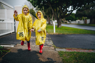 Obraz premium Twin sisters outdoors in raincoats