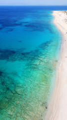 Fototapeta na wymiar Aerial bird's eye view photo taken by drone of tropical white sandy beach with turquoise clear waters