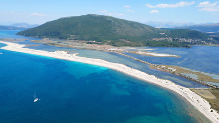 Aerial drone photo of famous for watersports like kitesurfing sandy turquoise beach of Agios Ioannis with old abandoned wimdills and lovely clouds, Lefkada island, Ionian, Greece