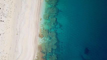 Aerial top view photo of sun beds in popular tropical paradise deep turquoise sandy beach of Kathisma, Lefkada island, Ionian, Greece