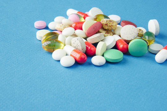 Pills are scattered over a blue background