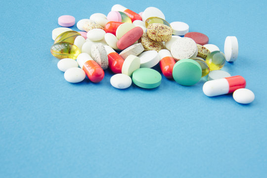 Pills are scattered over a blue background