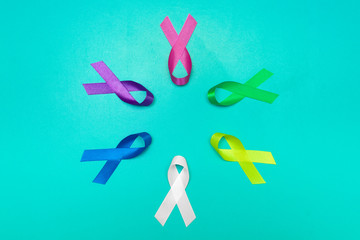 World cancer day background. Colorful ribbons, cancer awareness. blue surface from above.