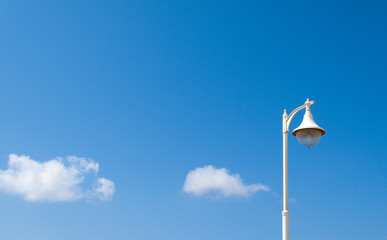 historic white street lamp with text space in the blue sky background with white clouds