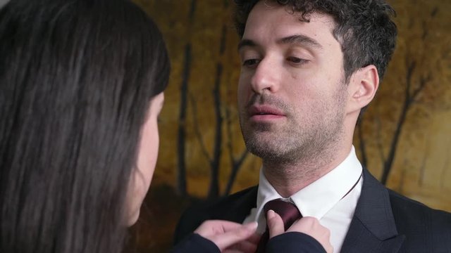 close up on Young wife helping her husband With Tie Business Dress