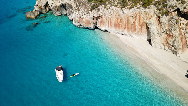 Aerial drone bird's eye view photo of popular beach of Milos with turquoise clear waters and sun beds, island of Lefkada, Ionian, Greece