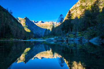 Mountains reflected in an alpine lake at sunrise