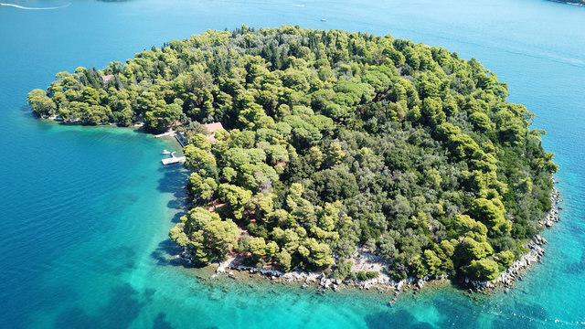 Aerial drone photo of iconic uninhabited island of Madouri in bay of Nydri and Mansion of 19th-century poet Aristotelis Valaoritis, Lefkada, Ionian, Greece