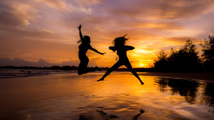 silhouette of woman jumping on the beach at sunset