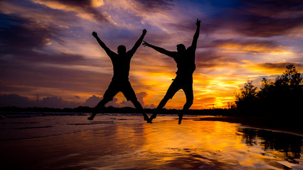 silhouette of woman jumping on the beach at sunset