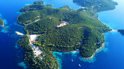 Aerial drone bird's eye view panoramic photo of iconic island of Skorpios that was owned by Aristotle Onasis and port of Nidri at the background, Lefkada island, Ionian, Greece