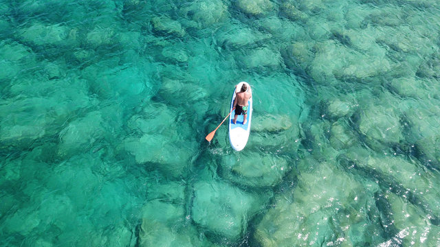 Aerial drone photo of couple practicing Stand Up Paddle or SUP in tropical exotic emerald and sapphire island sea - Powered by Adobe