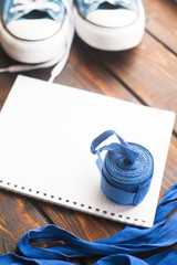 Time for diet slimming weight loss concept. Sport fitness, apple, sneakers, bottle of water and yellow weights on dark wooden background