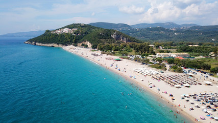 Aerial drone bird's eye view of popular beach of Karavostasi with beautiful clouds and turquoise sandy beach full of sunbeds at summertime, Epirus, Ionian, Greece